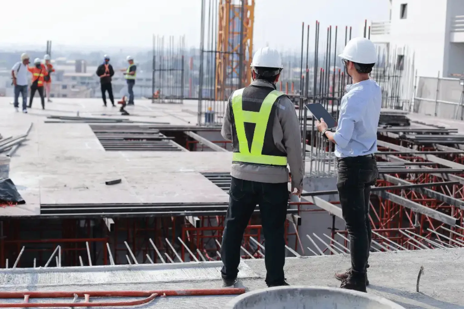 Engineers and labourers reviewing rebar work on a construction site in Greater Noida