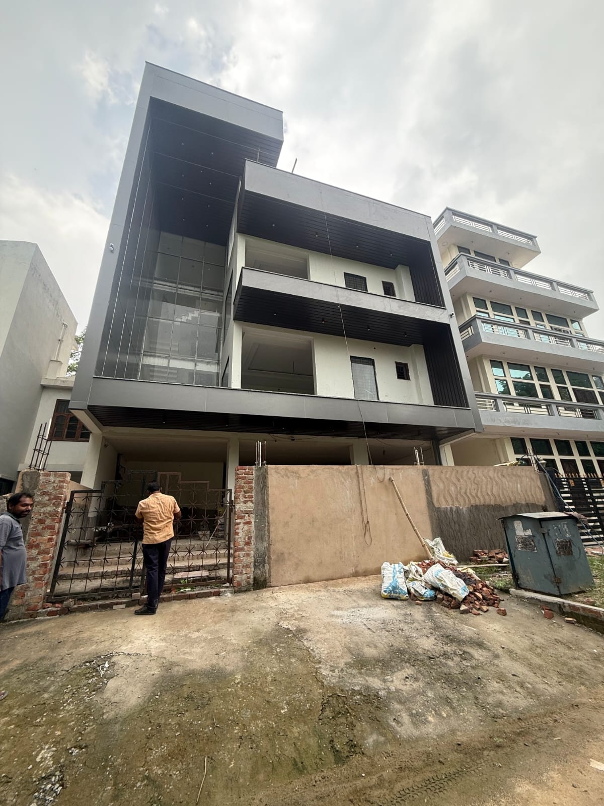 Modern two-story house with glass walls and landscape lighting at dusk