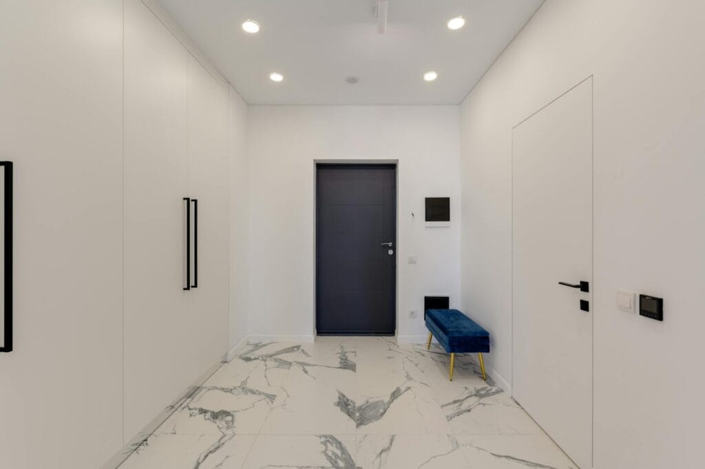 Modern home hallway with white-and-grey marble flooring and minimalist wardrobes