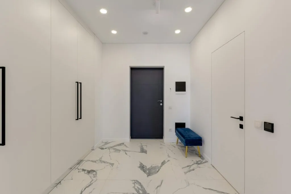 Modern home hallway with white-and-grey marble flooring and minimalist wardrobes
