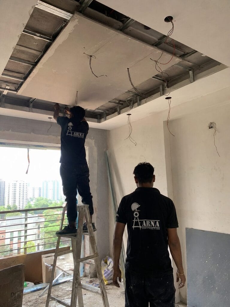 Aarna Constructions team installing false ceiling framing in a Greater Noida flat