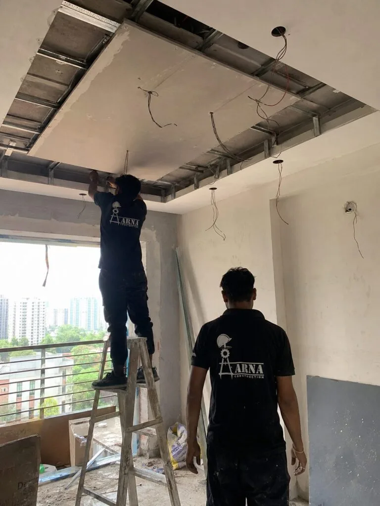 Aarna Constructions team installing false ceiling framing in a Greater Noida flat