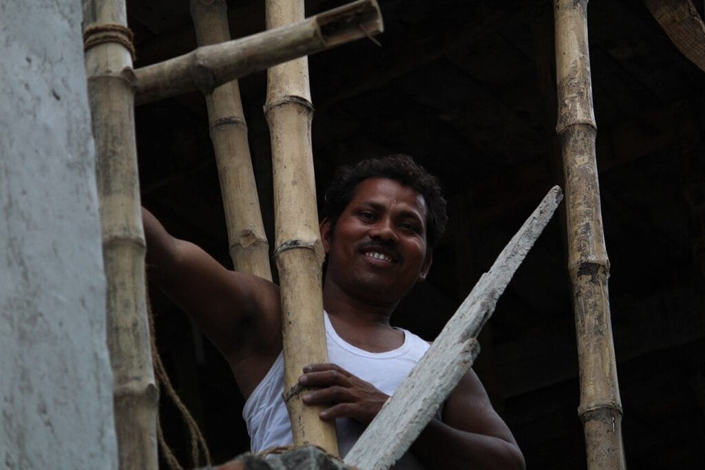Construction worker on bamboo scaffolding at an Indian house construction site, the stage when owners release payments