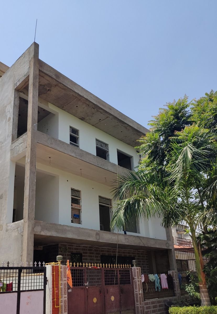 Multi-storey RCC frame house under construction in Greater Noida, with the concrete slabs cast, the walls up and finishe