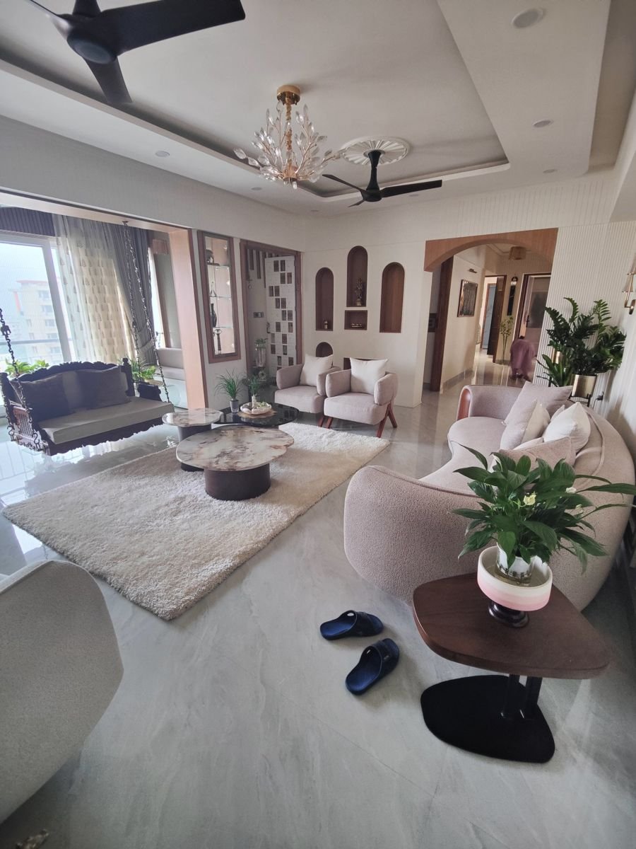 A finished living room interior in Greater Noida, designed with a false ceiling and cove lighting, a mirrored storage do