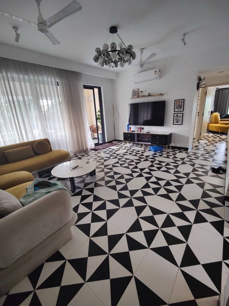 Living room interior in Greater Noida with a bold black-and-white geometric tile floor