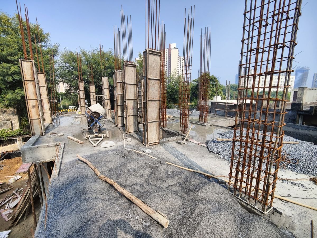 Column shuttering and reinforcement cages ready for the next concrete pour at a house construction site in Greater Noida